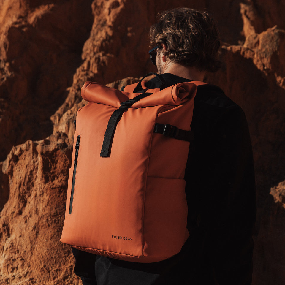 Man with back to camera wearing The Roll Top in Ember Orange