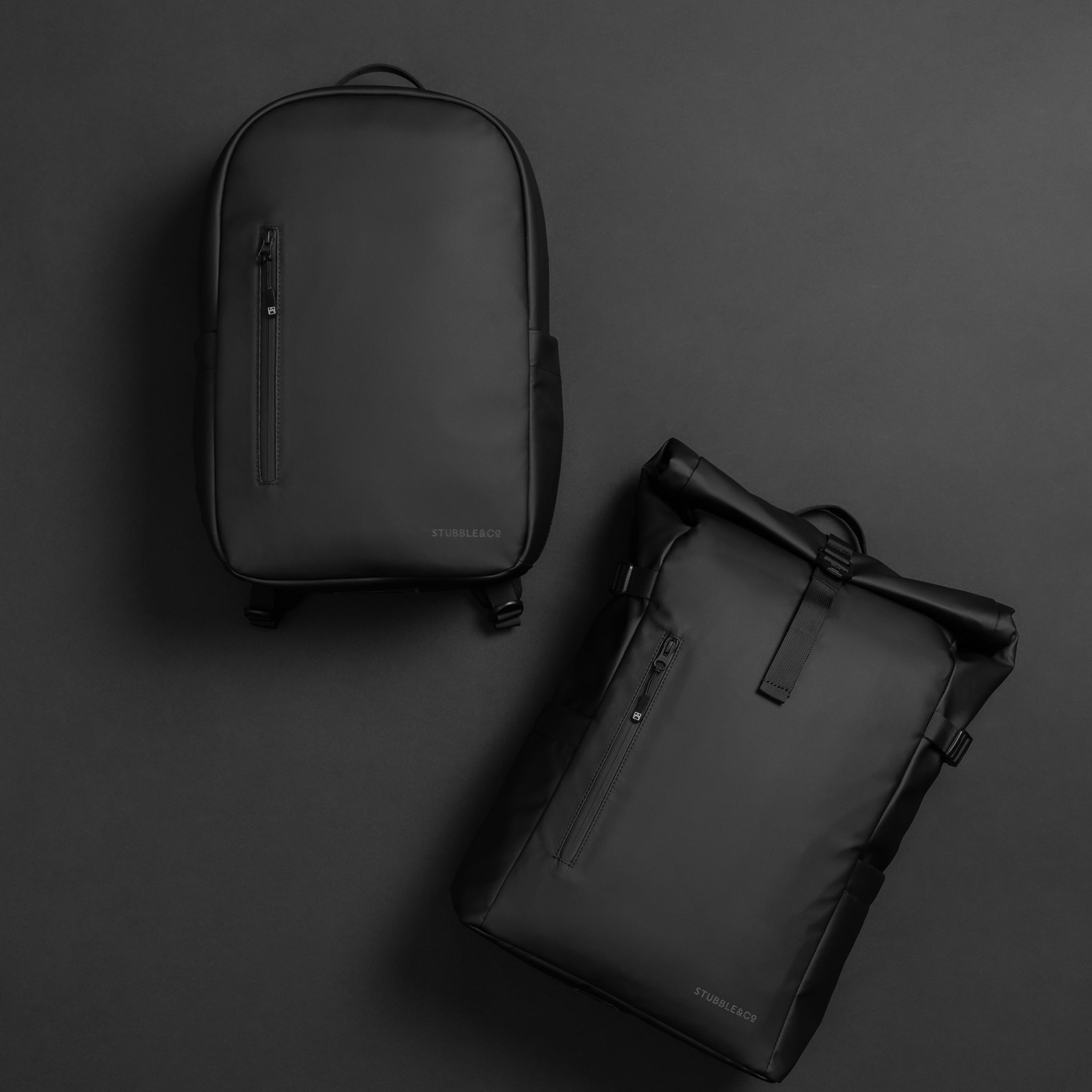 A studio flat lay of a everyday backpack and roll top 20l on a black background