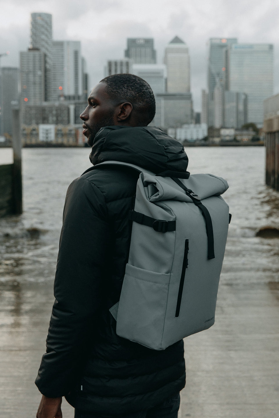 Man with Roll Top Mini backpack in grey