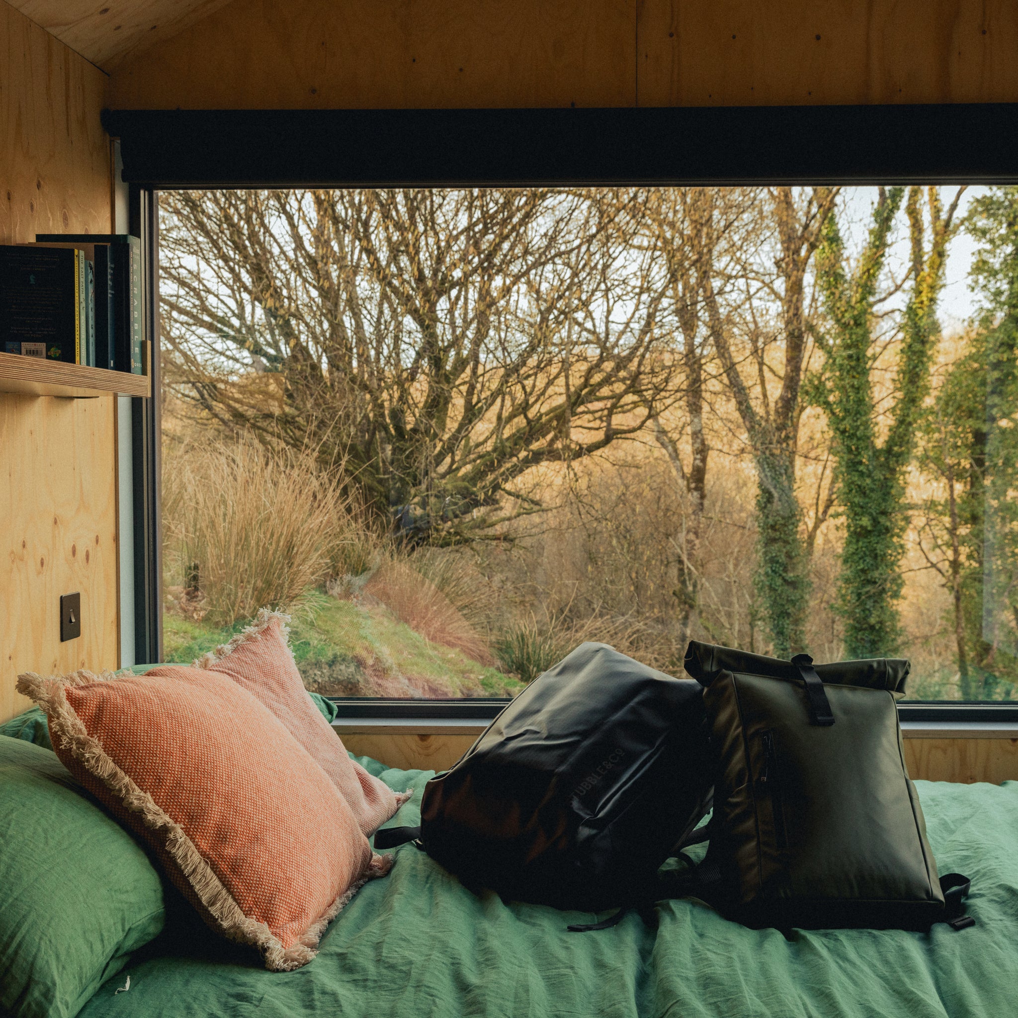 A Kit Bag 30L and Roll Top 20L on a bed in an unplugged cabin