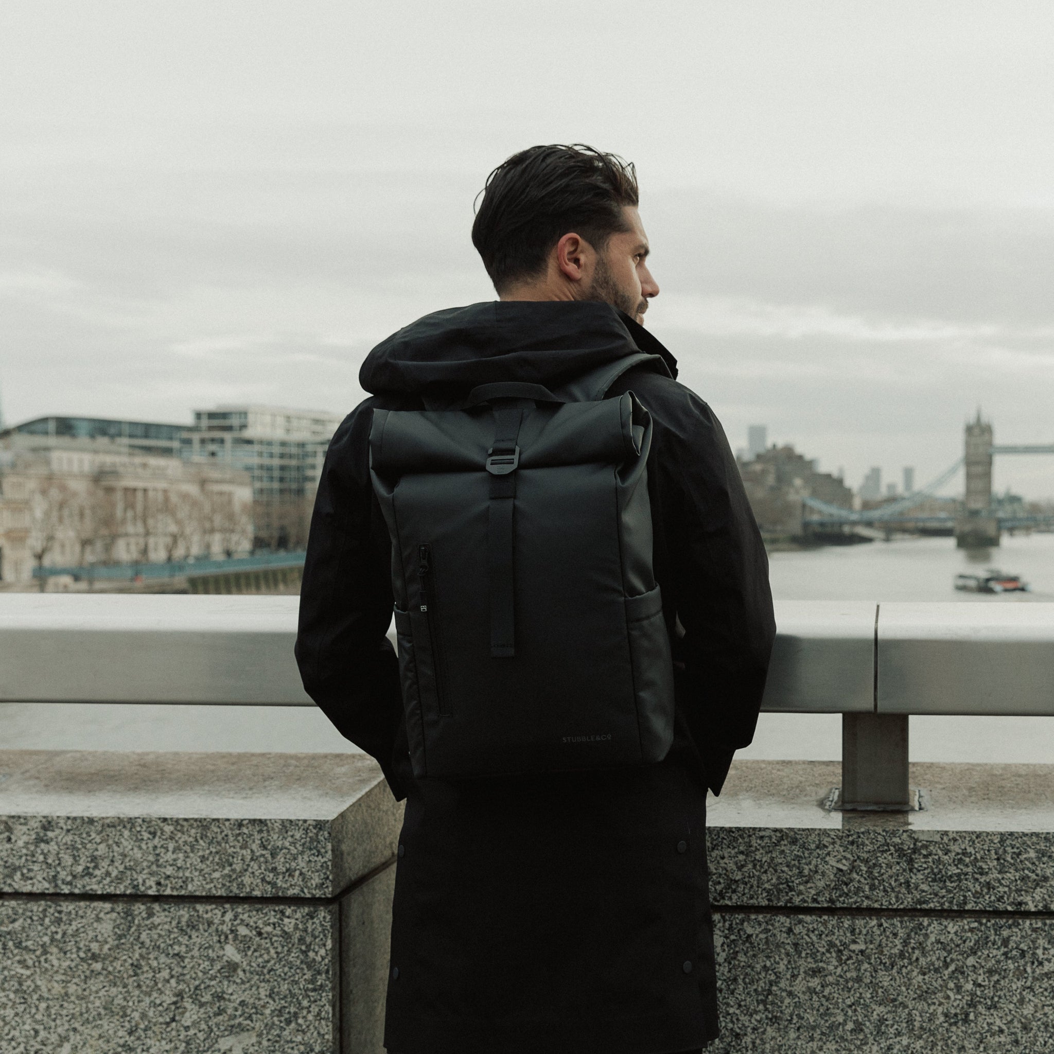 Man wearing Roll Top Mini backpack in All Black