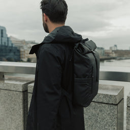 Man wearing Roll Top Mini backpack in All Black