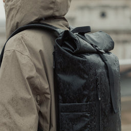Roll Top Mini backpack in All Black in the rain