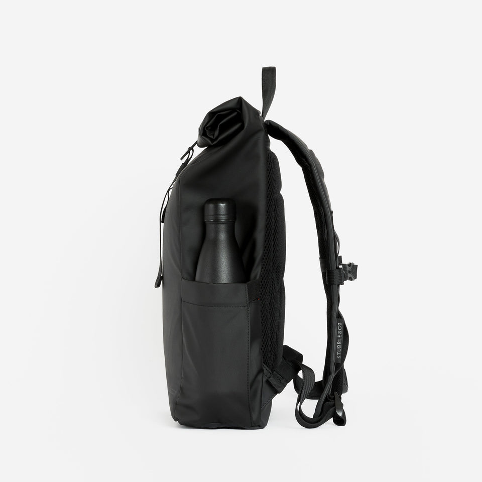 Side product shot of The Roll Top Mini in All Black with a water bottle in the side pocket.