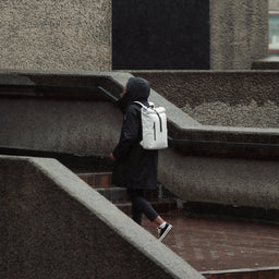 Women walking in the rain wearing Roll Top Mini backpack in Arctic White