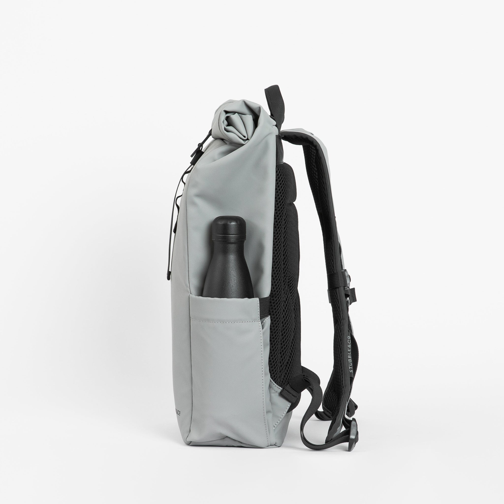 A side view of the bottle pocket on the Roll Top Mini backpack in Concrete