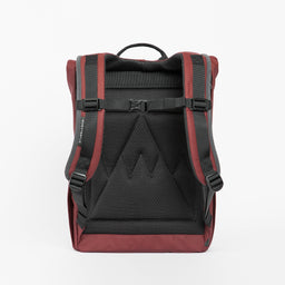A studio shot of the back panel on a Roll Top Mini backpack in Earth Red