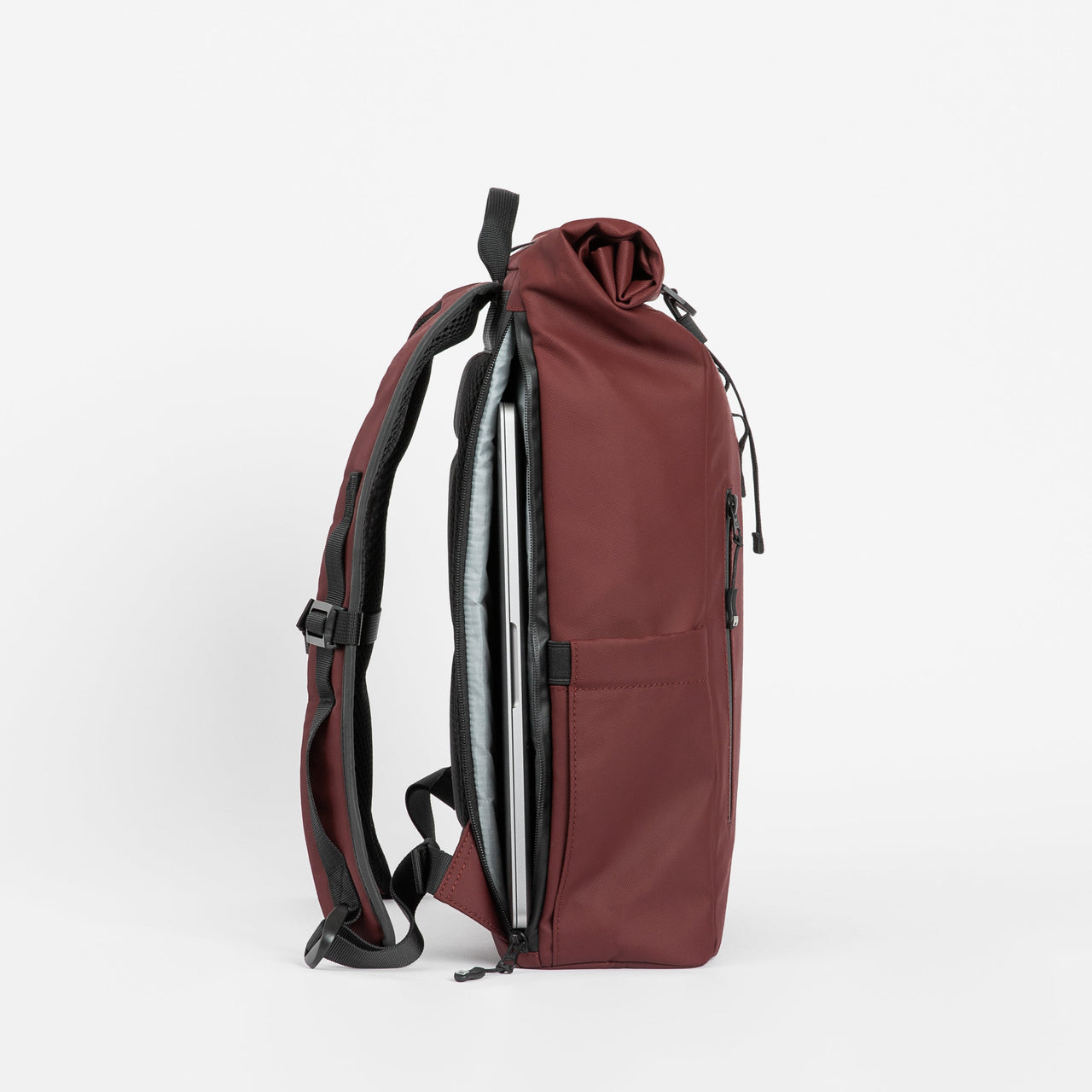 A studio shot of the laptop compartment on a Roll Top Mini backpack in Earth Red