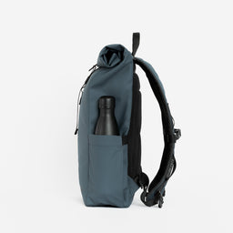 A studio shot of the bottle pocket of Roll Top Mini backpack in Tasmin Blue