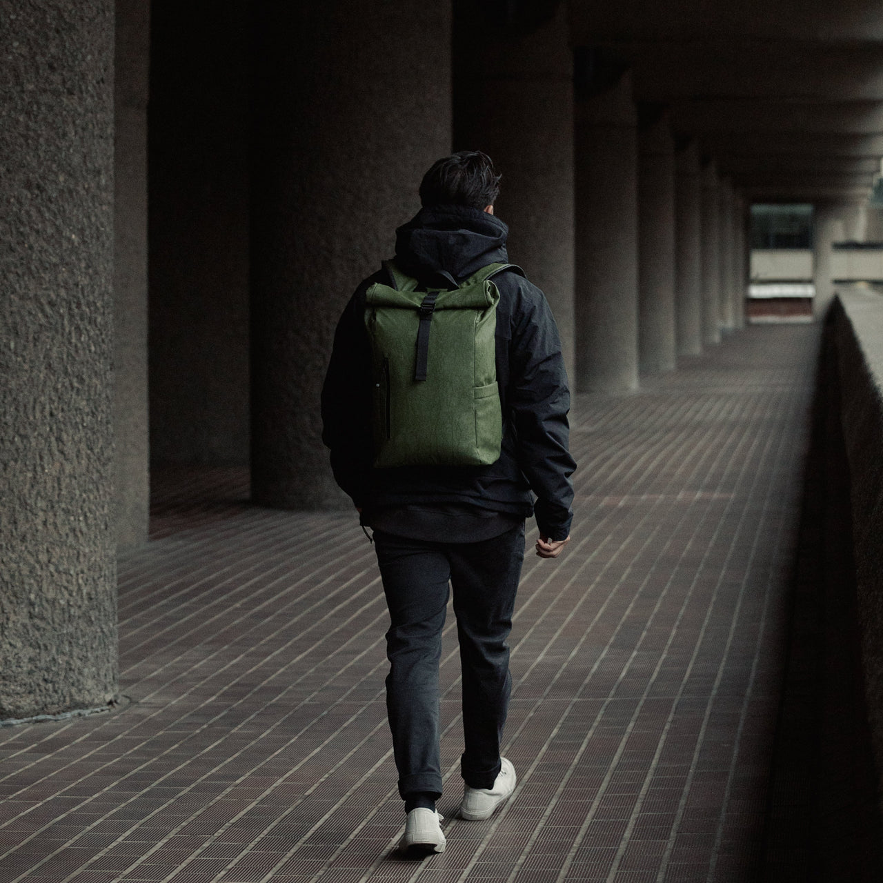 Man wearing Roll Top Mini backpack in  Urban Green