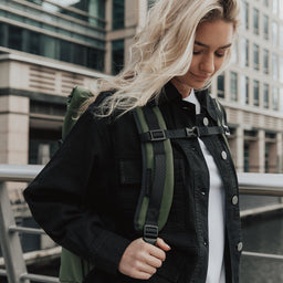 A women facing the camera wearing The Roll Top in Urban Green