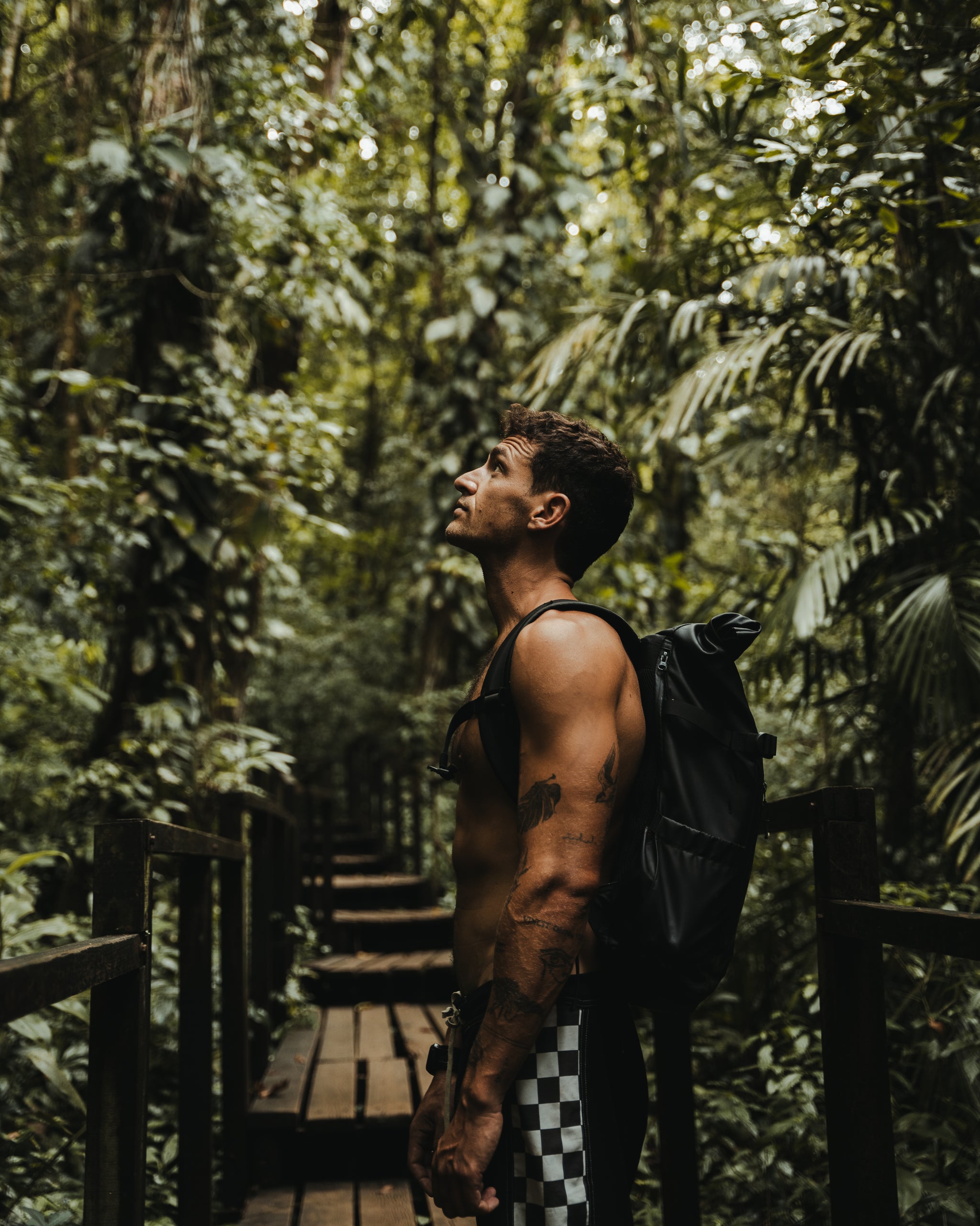Man in the Guatemalan jungle wearing a black Roll Top backpack