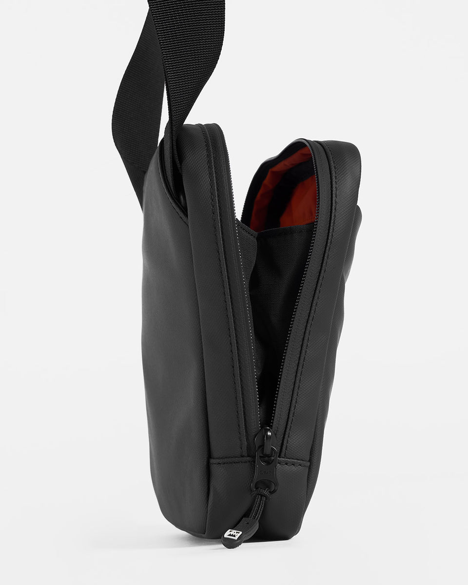A studio shot of an all black shoulder bag to show the wide opening for easy access