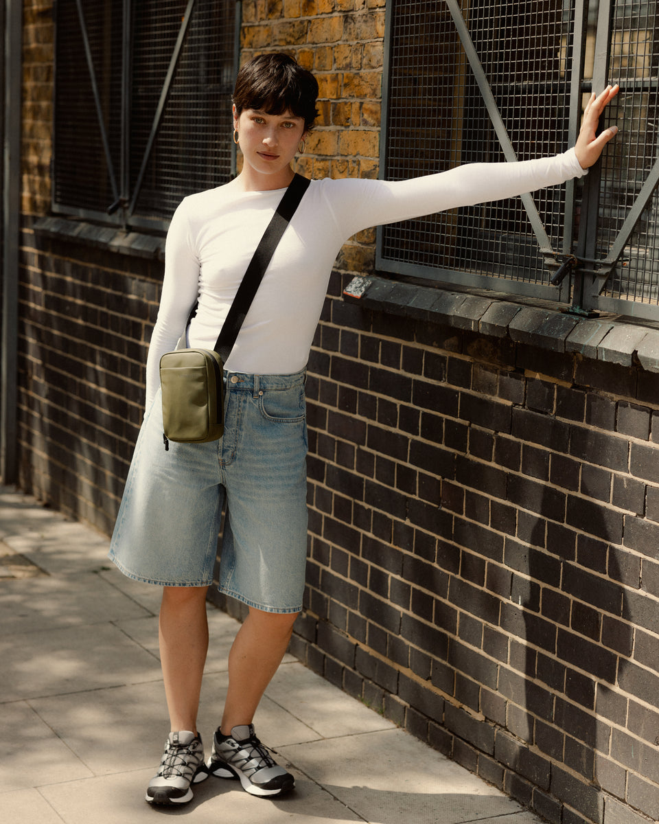 A woman wearing an urban green shoulder bag 