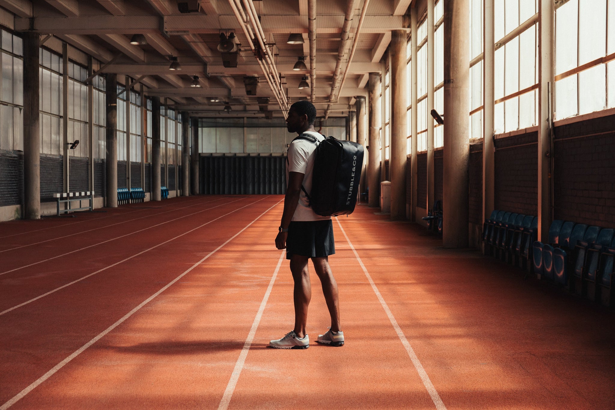 Man wearing bag standing on indoor running track