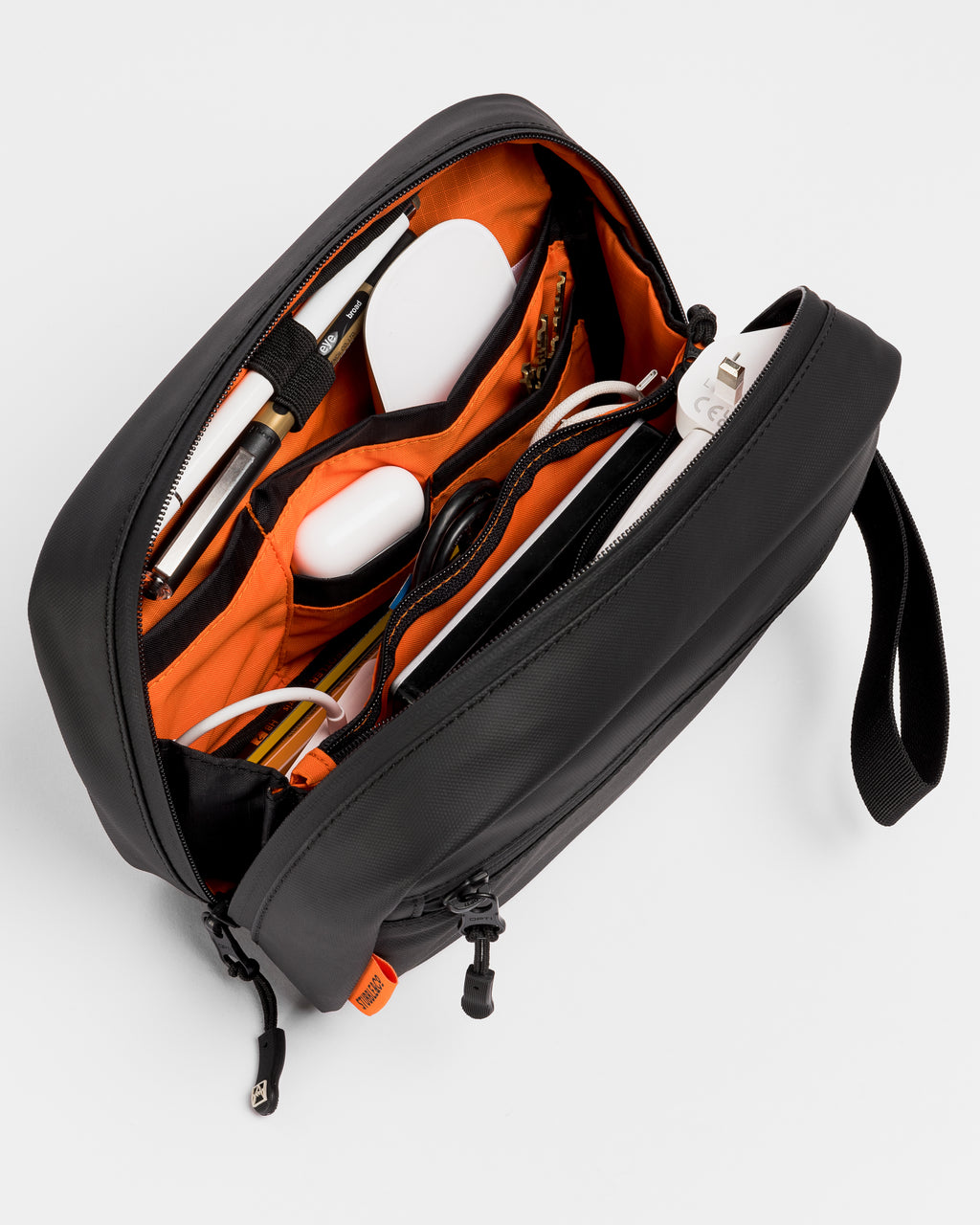A studio shot of the interior of the tech bag, packed with the daily essentials in a black tech bag