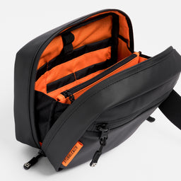 A studio shot of the orange lining in the tech bag in Urban Green