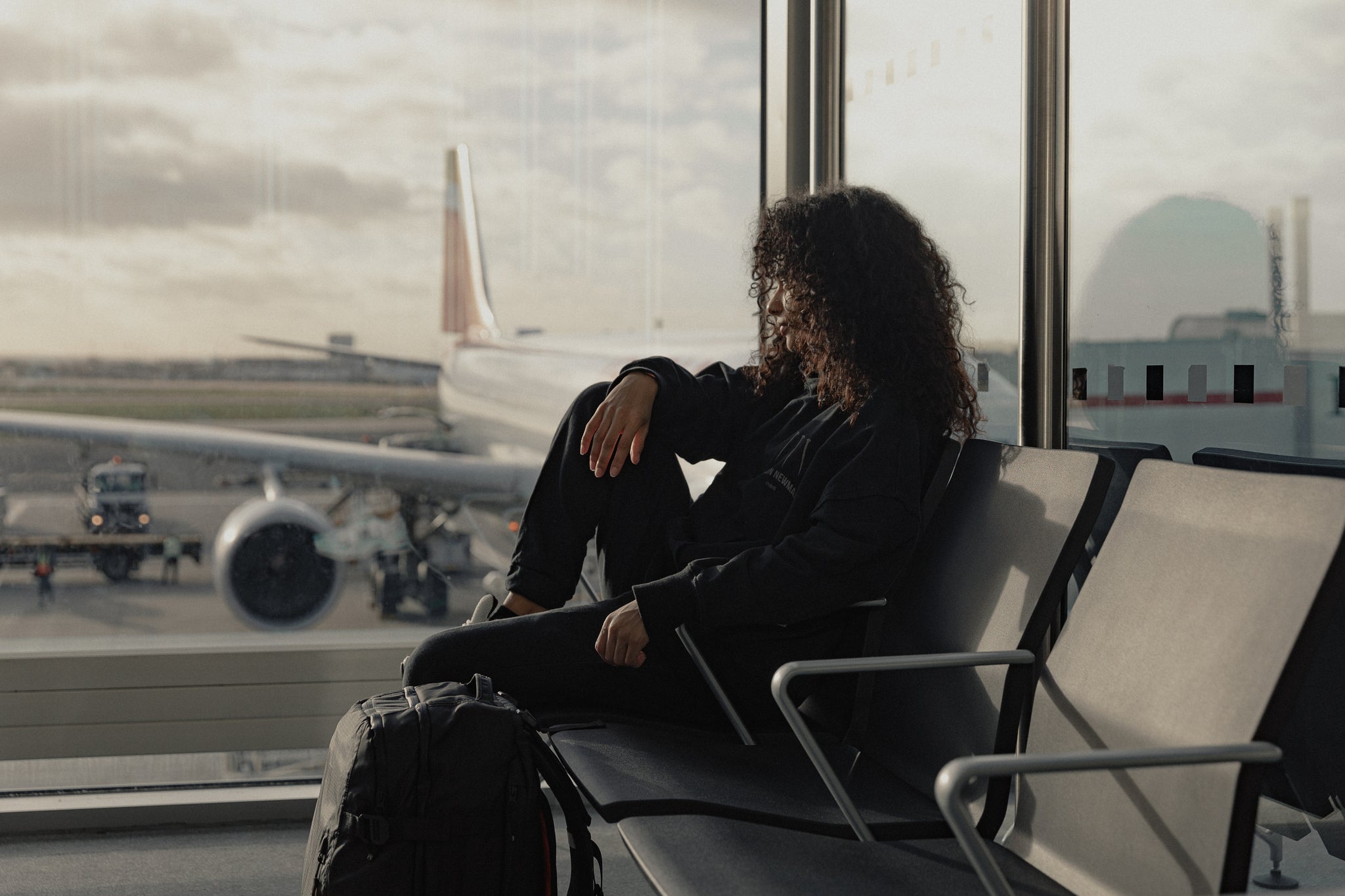 Women sitting at an airport with a black blackpack