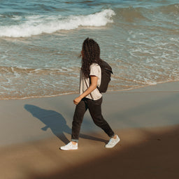 Women wearing The Backpack Mini in All Black on the beach