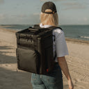 A women on a beach wearing The Cooler in All Black