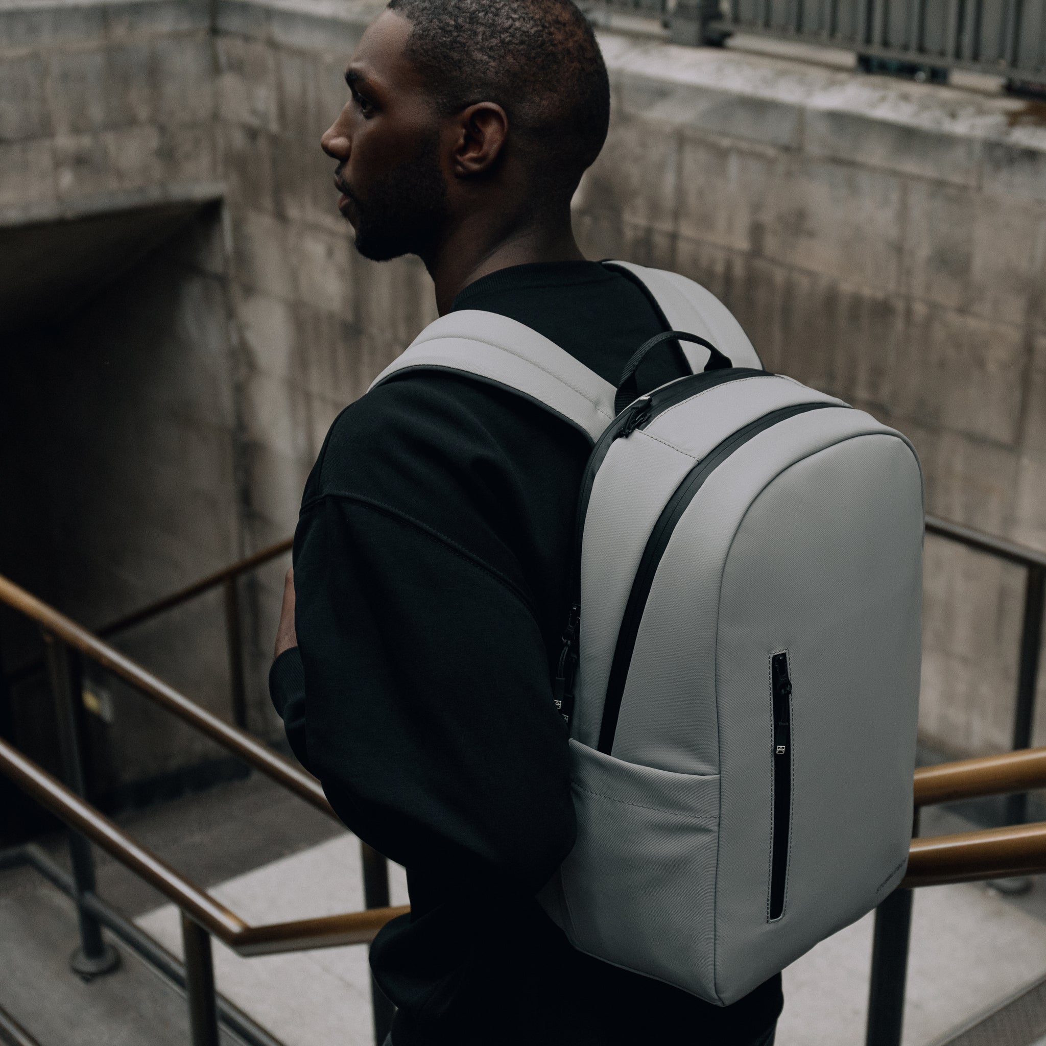 Man wearing The Everyday Backpack in Concrete