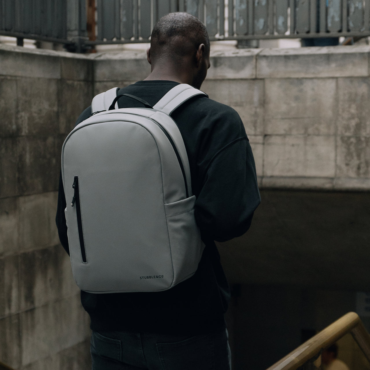 Man wearing The Everyday Backpack in Concrete