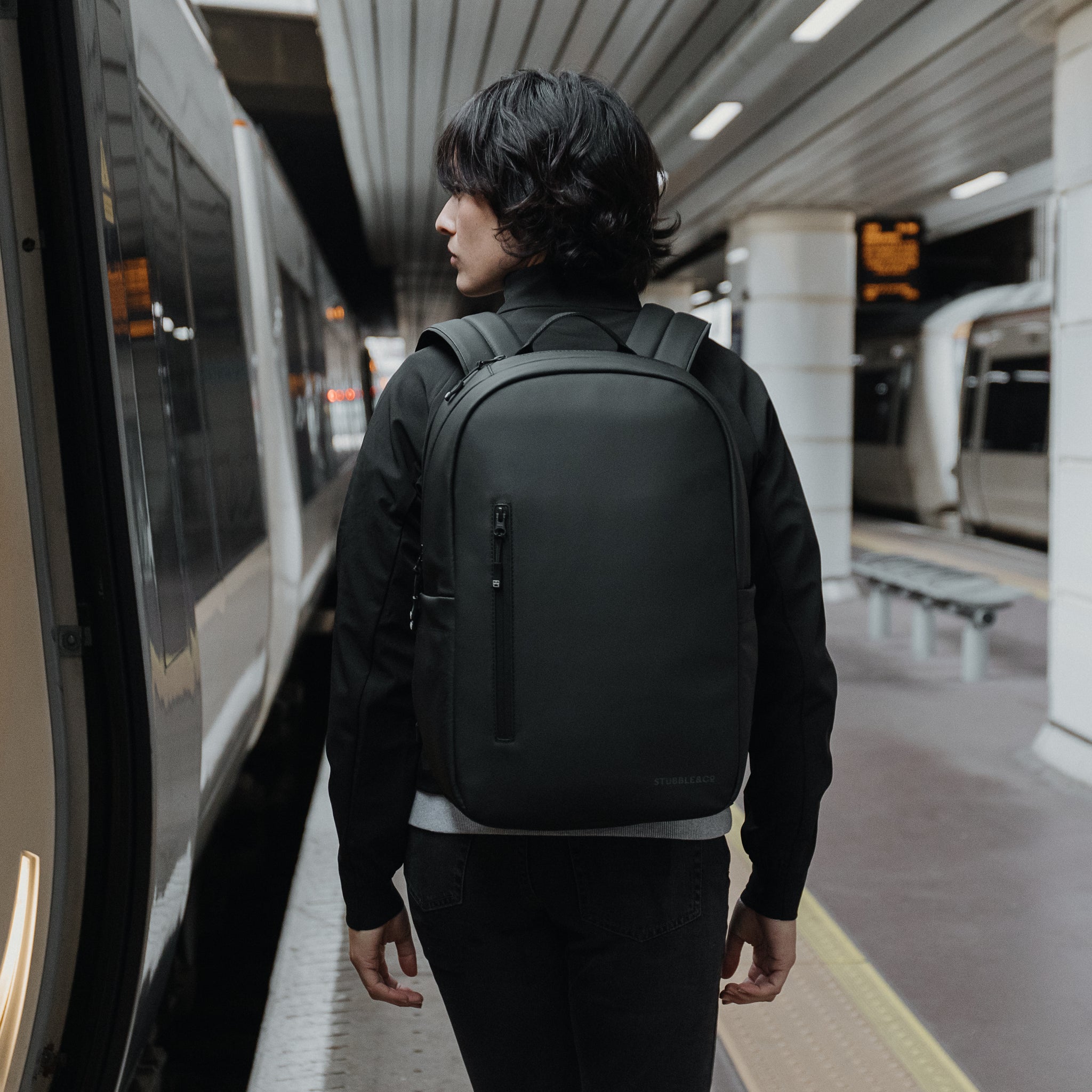Women with All Black Everyday Backpack by a train