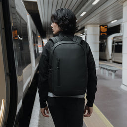 Women with All Black Everyday Backpack by a train