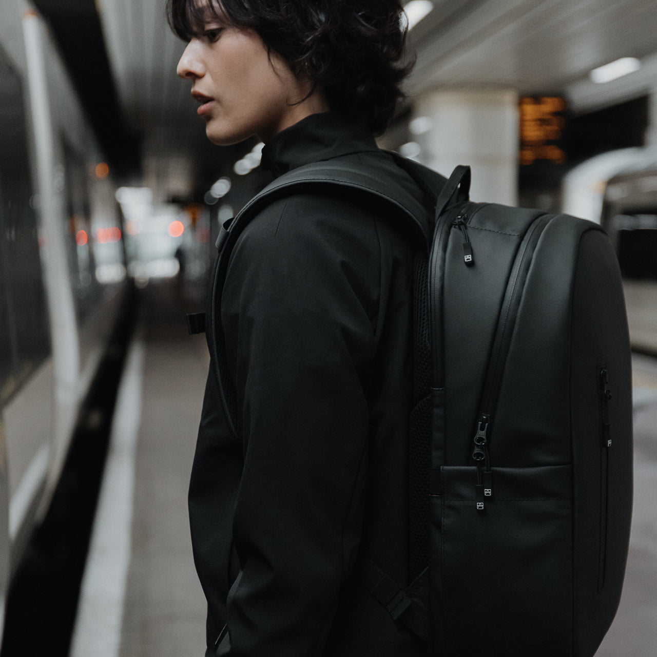 Women with All Black Everyday Backpack by a train