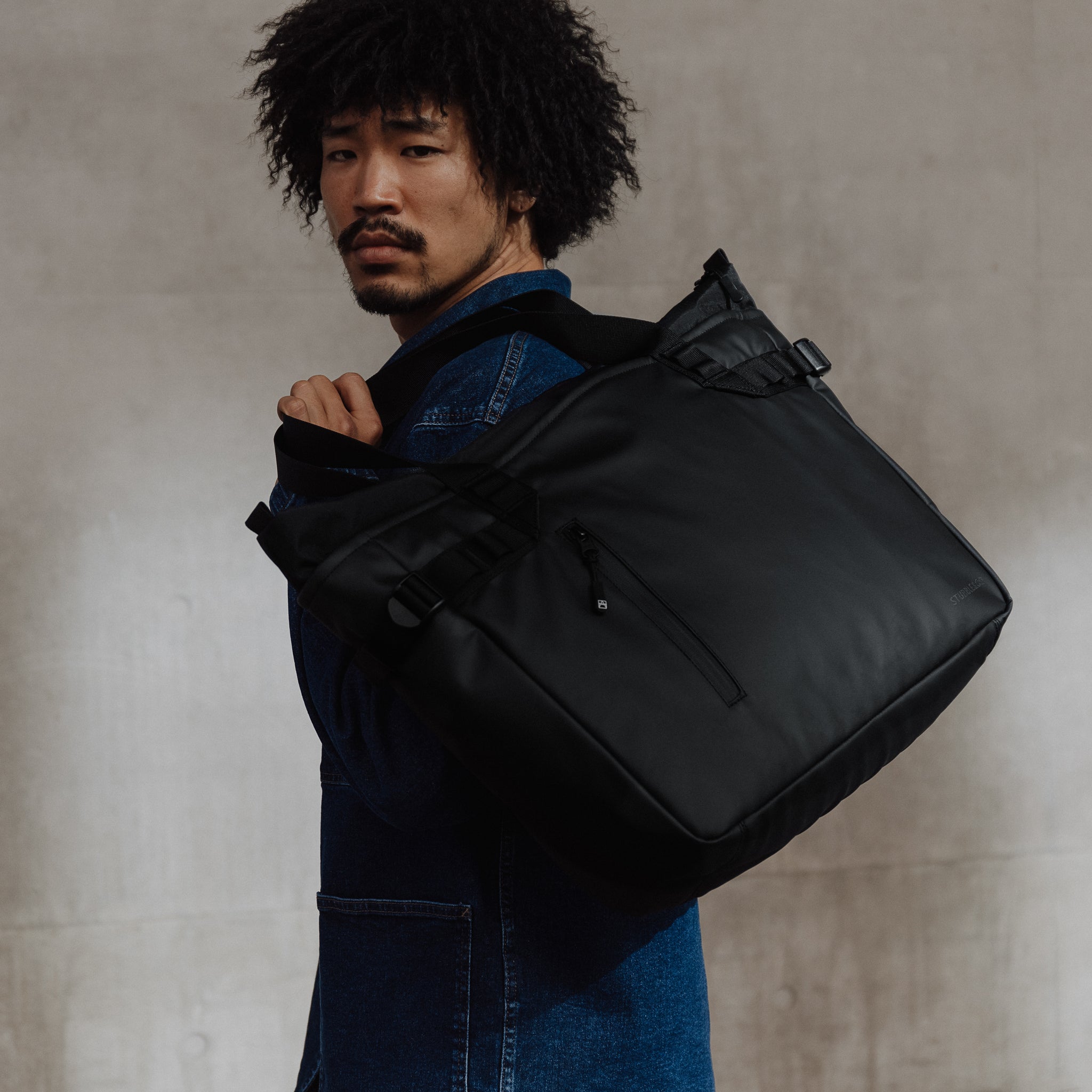 Male carrying The Tote Bag in All Black