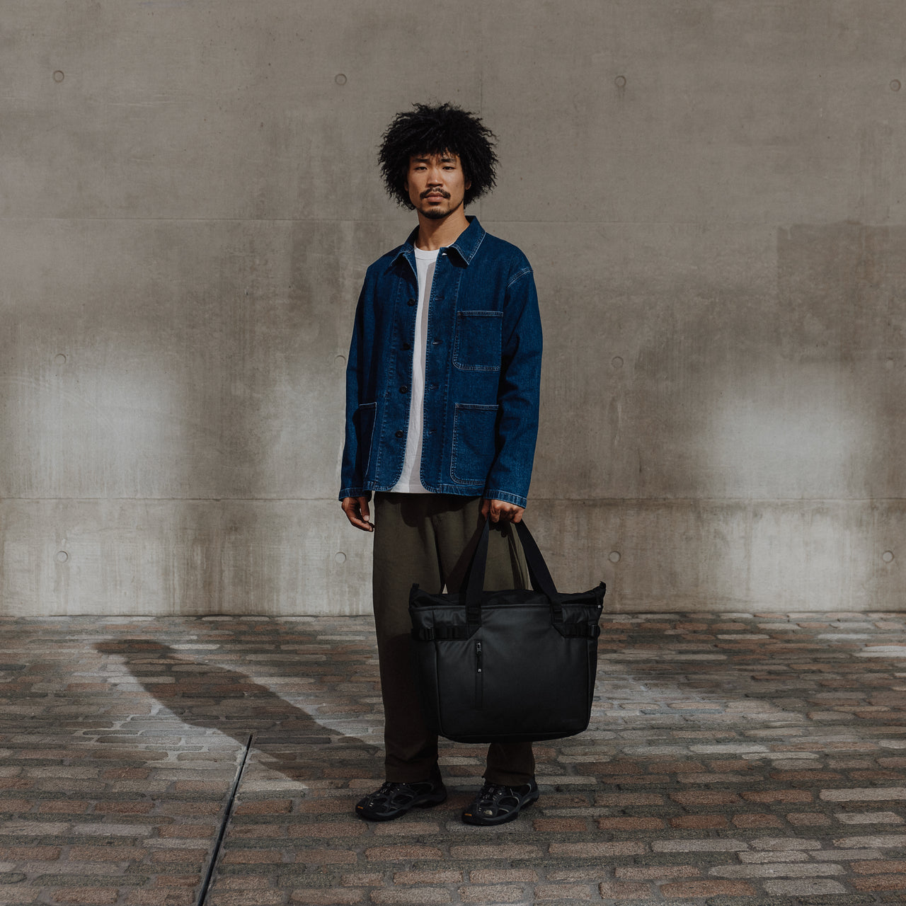 Male carrying The Tote Bag in All Black
