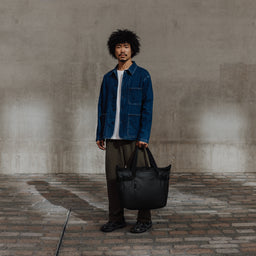 Male carrying The Tote Bag in All Black