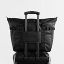 The Tote Bag in All Black with trolley sleeve on a suitcase