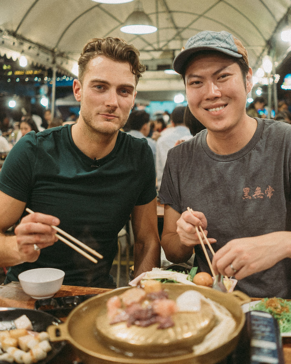 Men sitting in a market eating food
