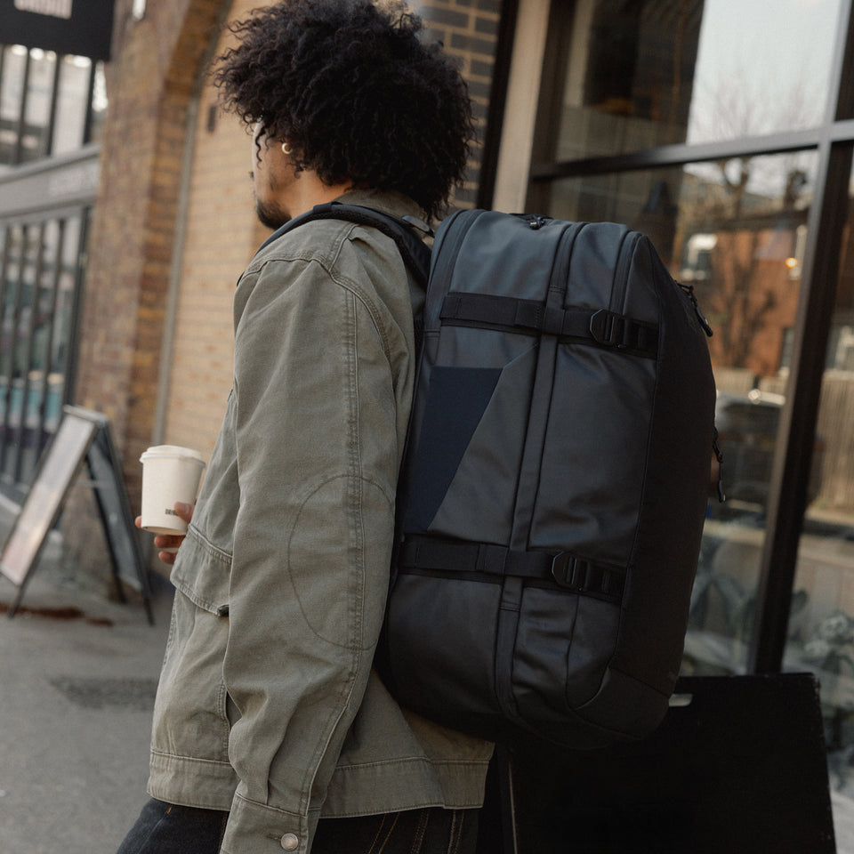 A man walking down the street with a travel backpack 40l on his back 
