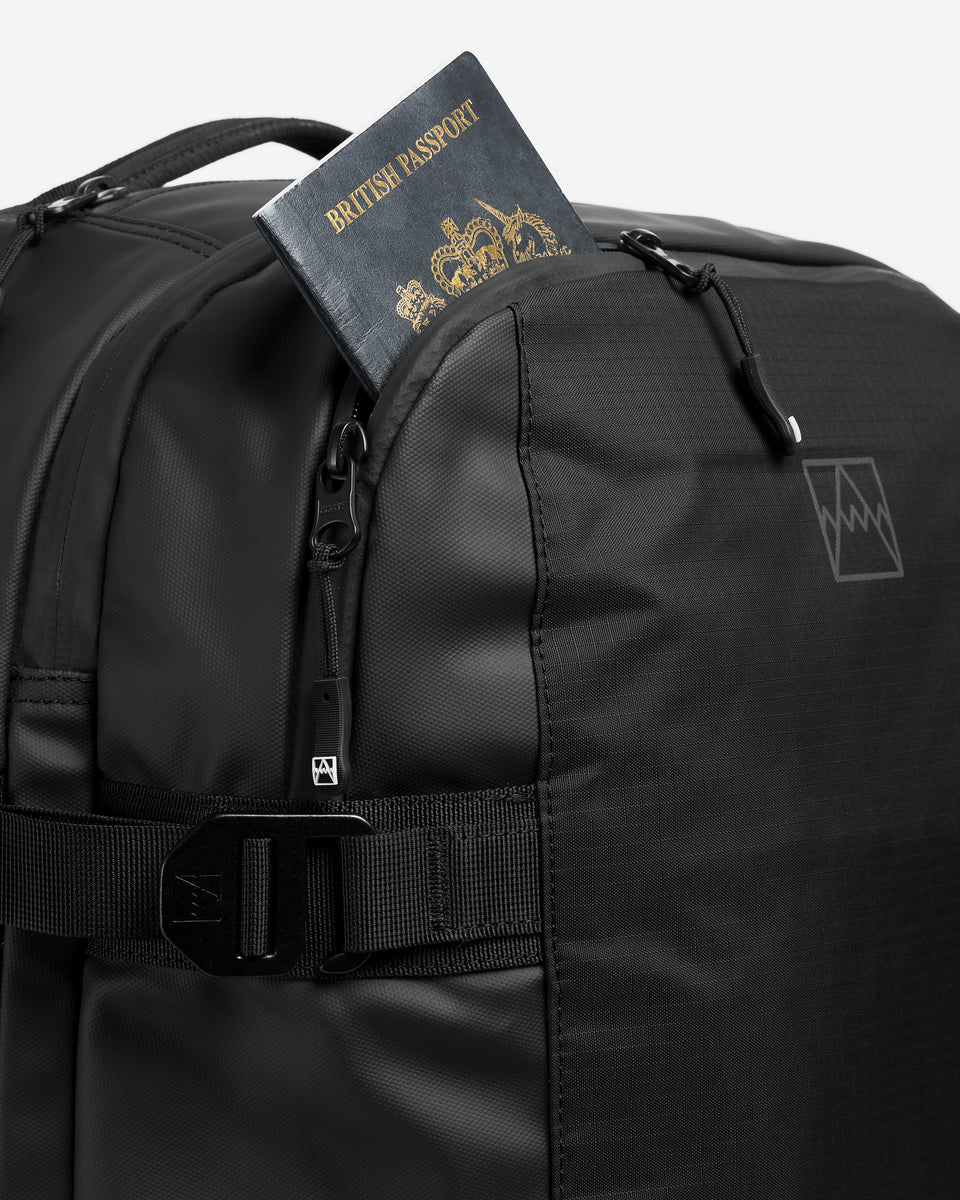 A studio shot of the front access pocket on the black travel backpack 40l
