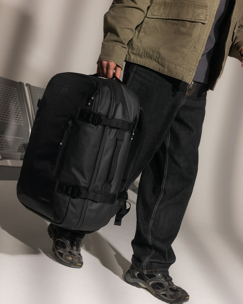 A man carrying a travel backpack 40l by his side