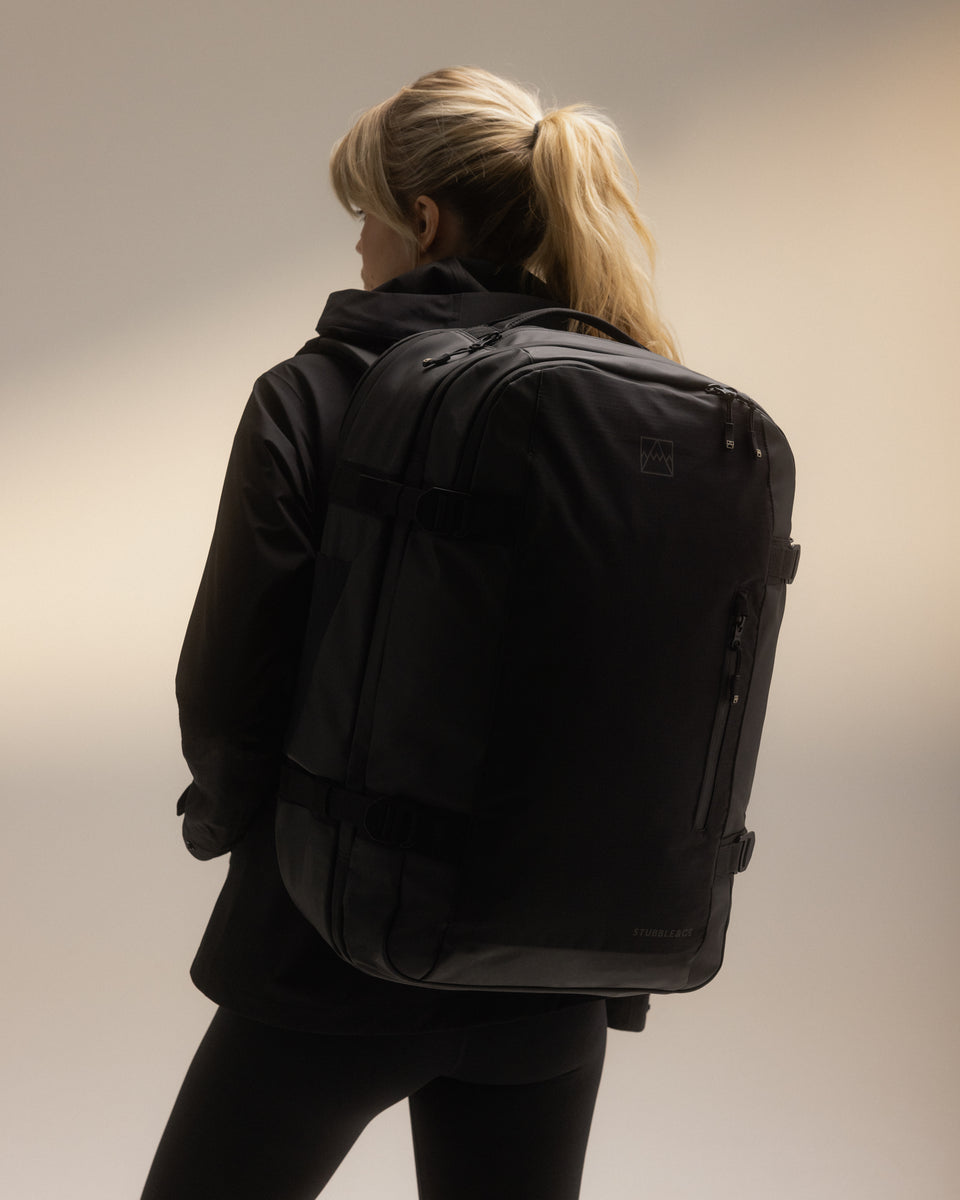 A woman wearing a black travel backpack 40l on her back
