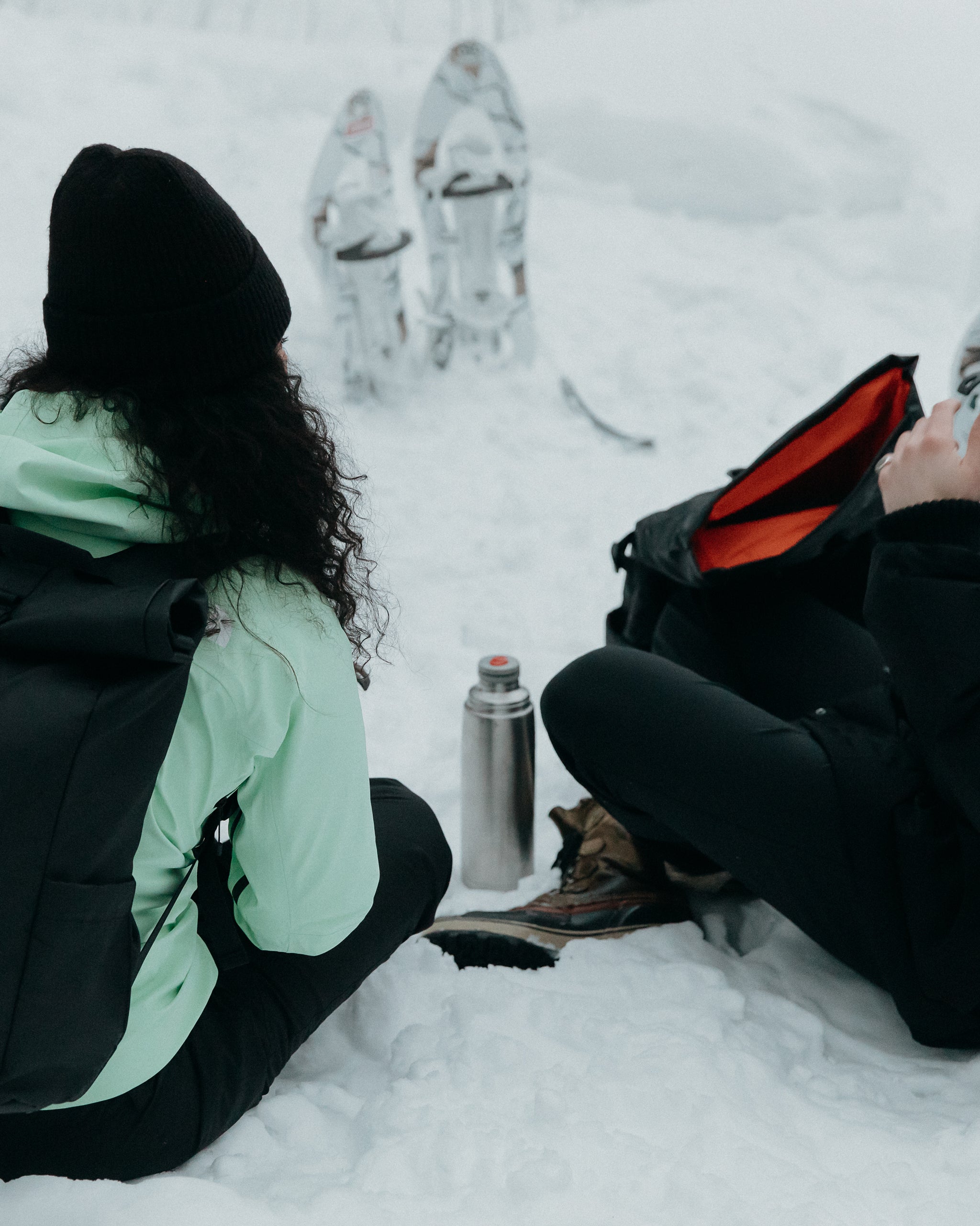 People sitting in the snow with flask of drinks in Finalnd