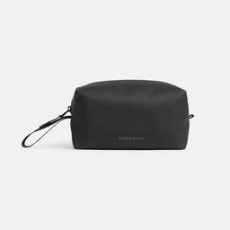 a studio shot of the back of an All Black wash bag showing the reflective logo