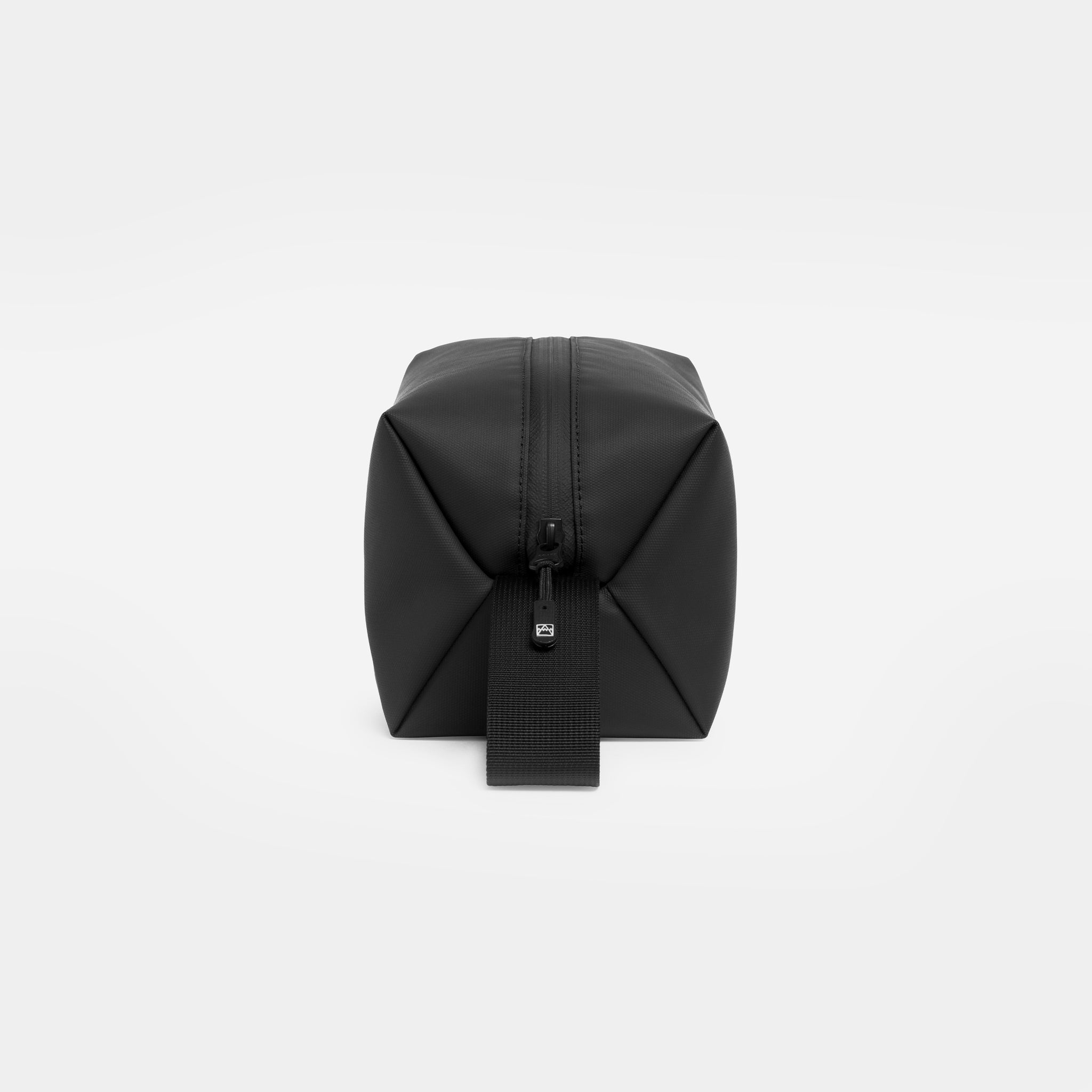 The end of an All Black wash bag showing the loop handle and zip