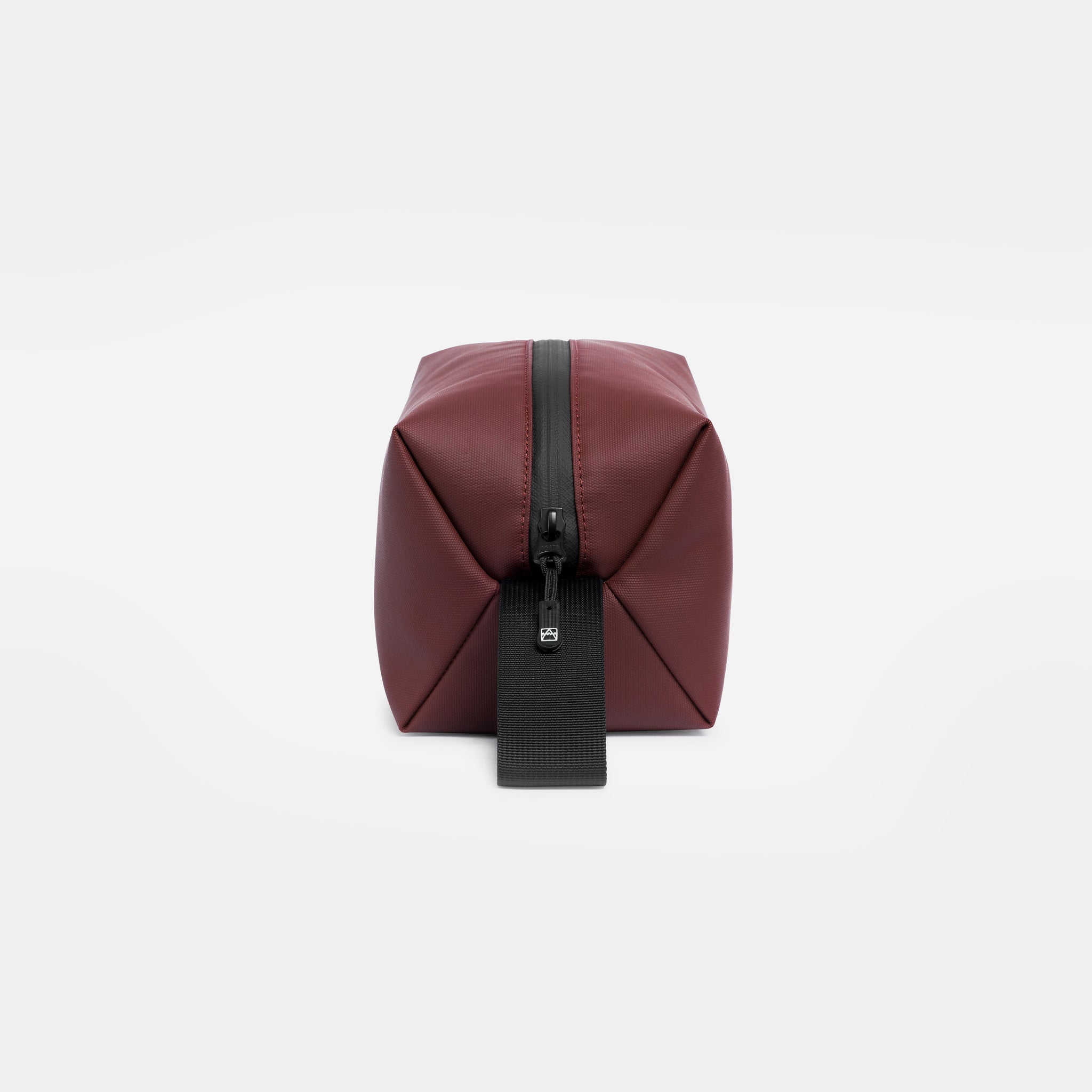 A studio shot of the end and loop handle on the Garnet Red Wash Bag