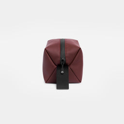 A studio shot of the end and loop handle on the Garnet Red Wash Bag