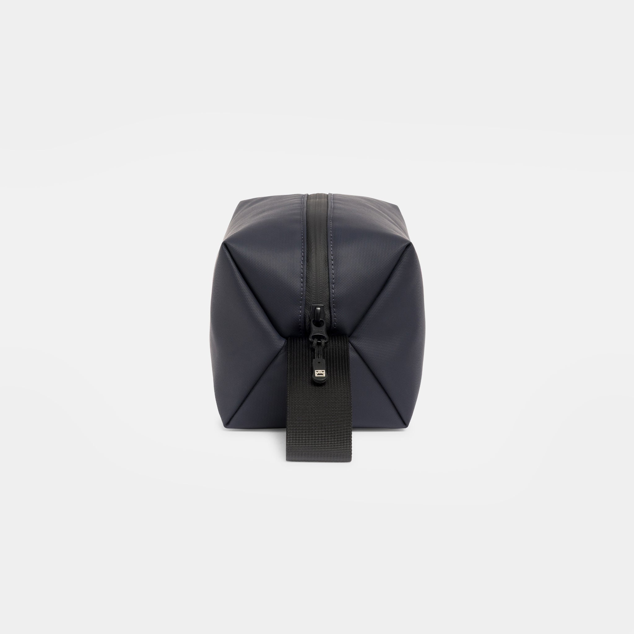 A studio shot of the end and grab handle on a Midnight Blue Wash Bag