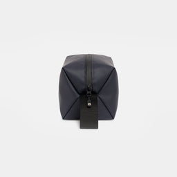 A studio shot of the end and grab handle on a Midnight Blue Wash Bag