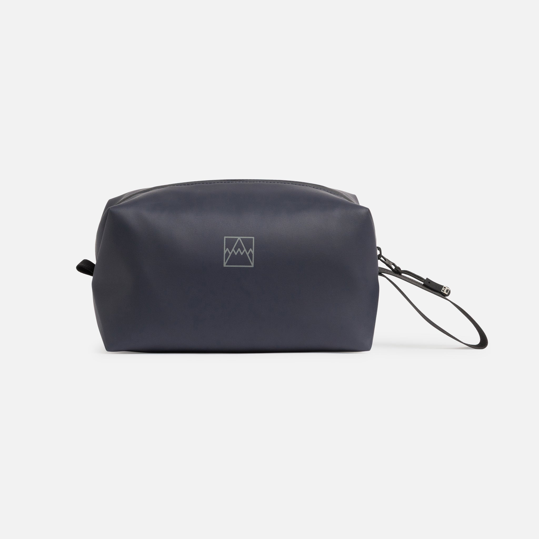 A studio shot of the logo on the side of a Wash Bag in Midnight Blue