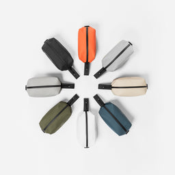 Collection of wash bags positioned in a circle, including Ember Orange