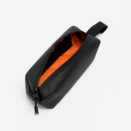 A studio shot of the orange lining and pockets of the pencil case in All Black
