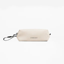 A studio shot of the Wash Bag Mini in Sand showing the logo on the back