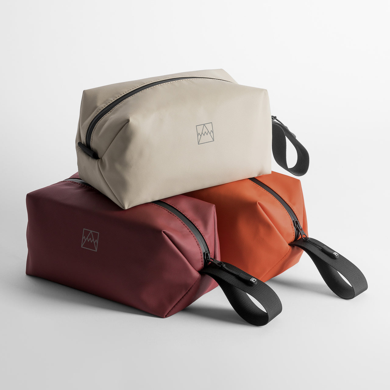 A studio shot of 3 Wash Bags from Stubble & Co including rust, sand and Garnet Red